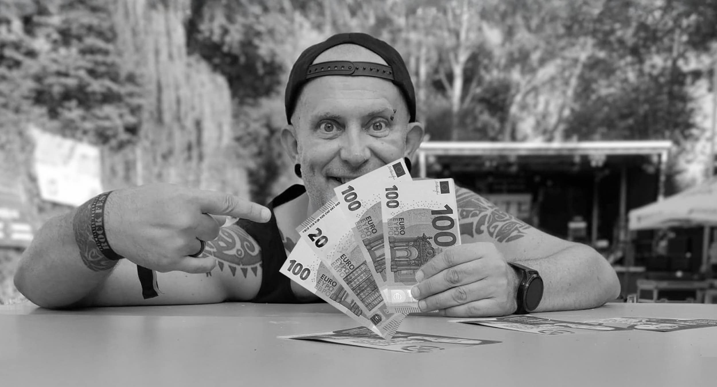 Walter von BLACKROCX mit einem Bündel voll Euro in der Hand.